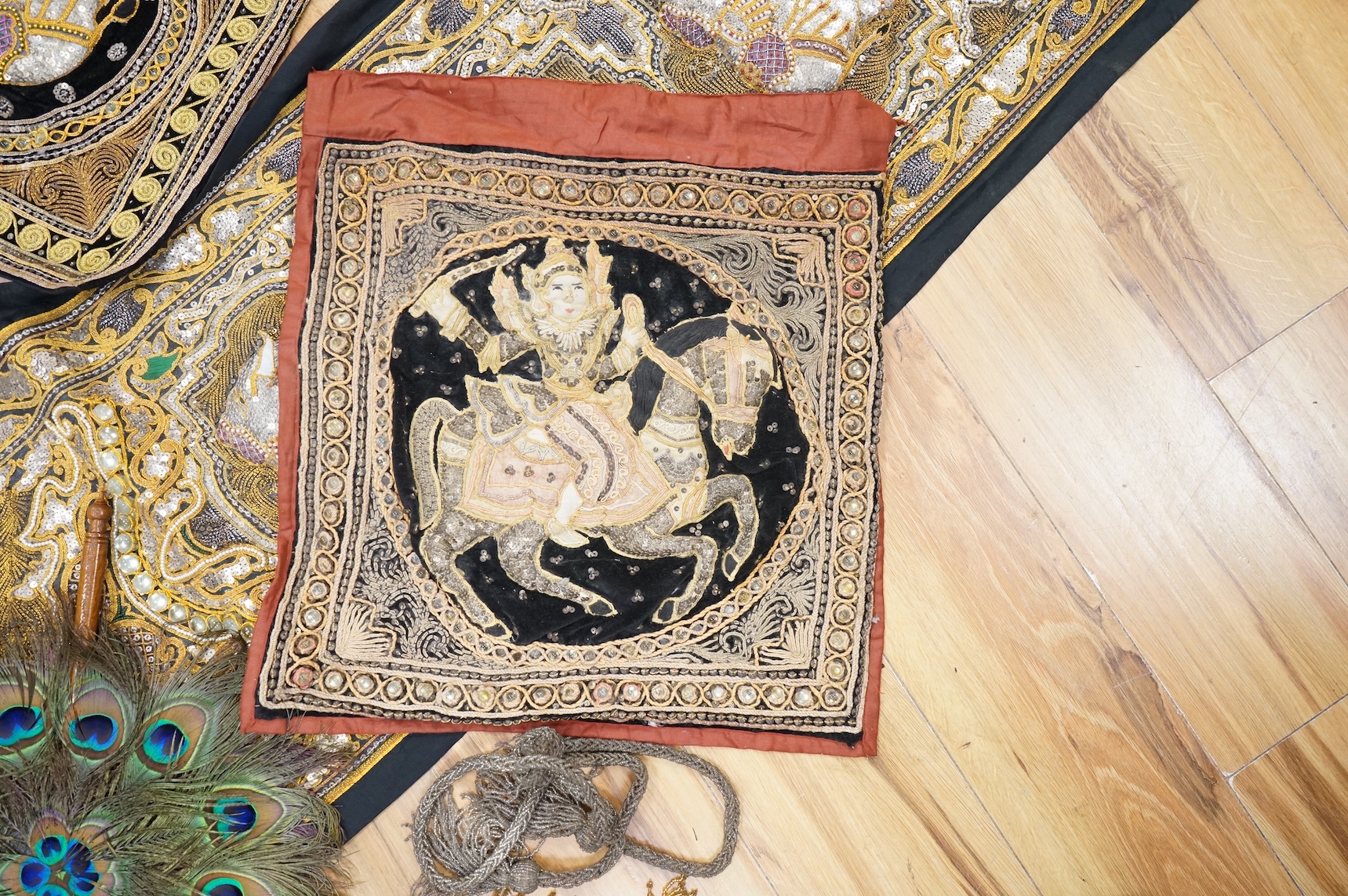 A quantity of mostly 20th century Middle Eastern and Indian woven and printed textiles and a peacock feather fan (2 boxes).